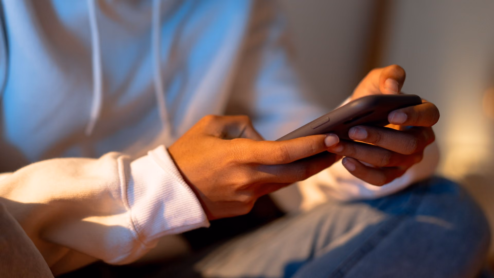 Image 1 (phone):  Close-up of a person scrolling on a smartphone in a dimly lit room