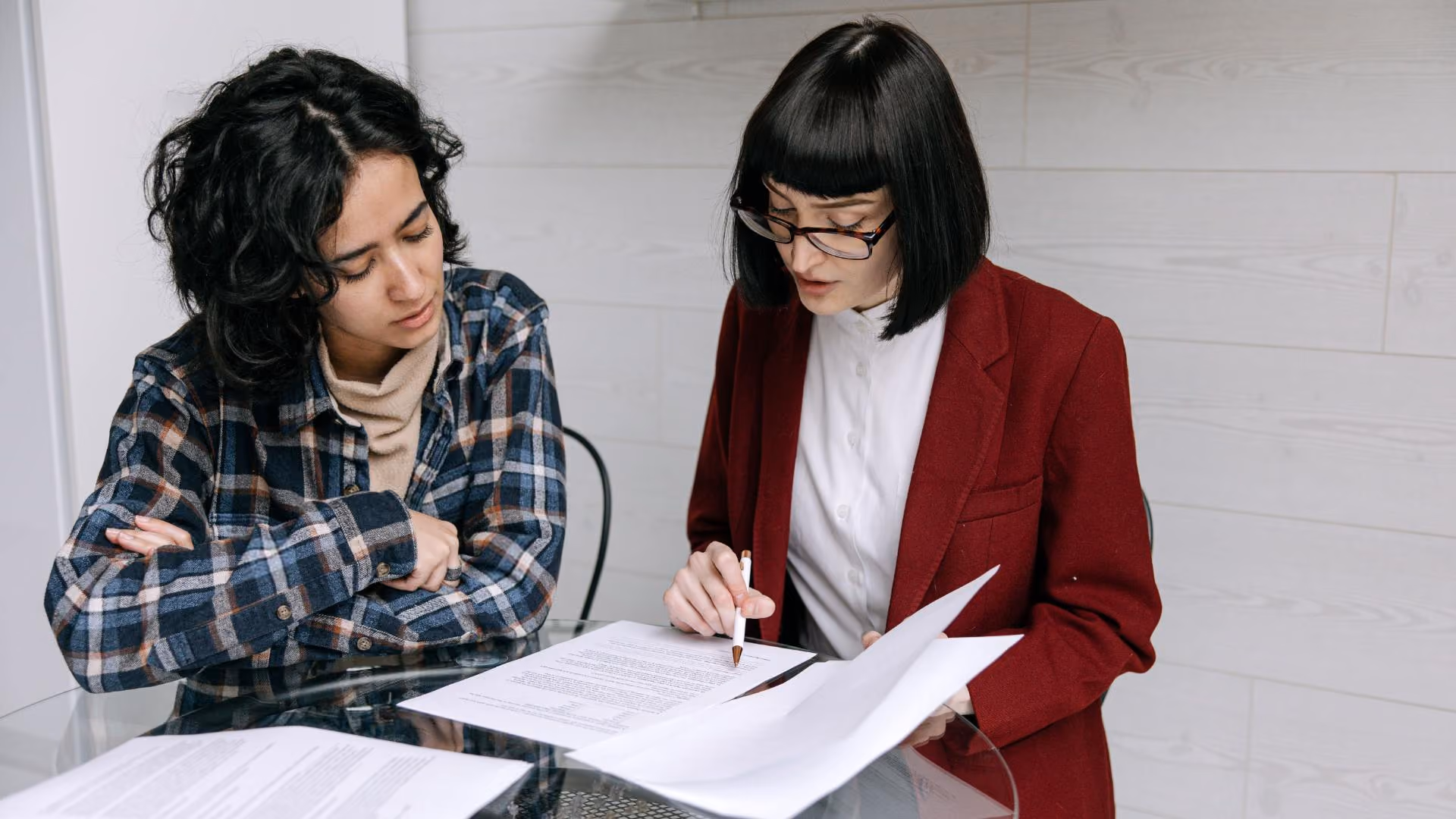 Two people reviewing paperwork together at a table.