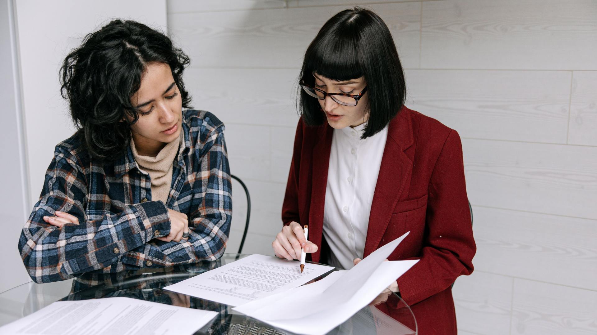 Two people reviewing paperwork together at a table.