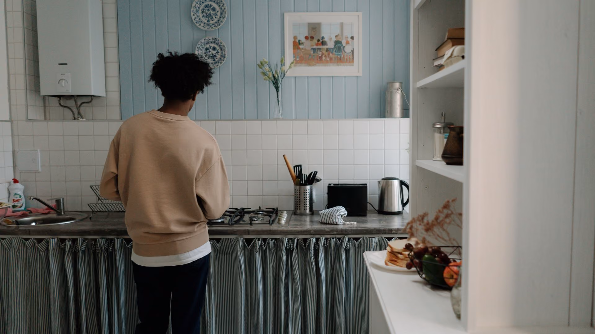 Resident standing in their kitchen at home, a quiet everyday moment of settling into a new place