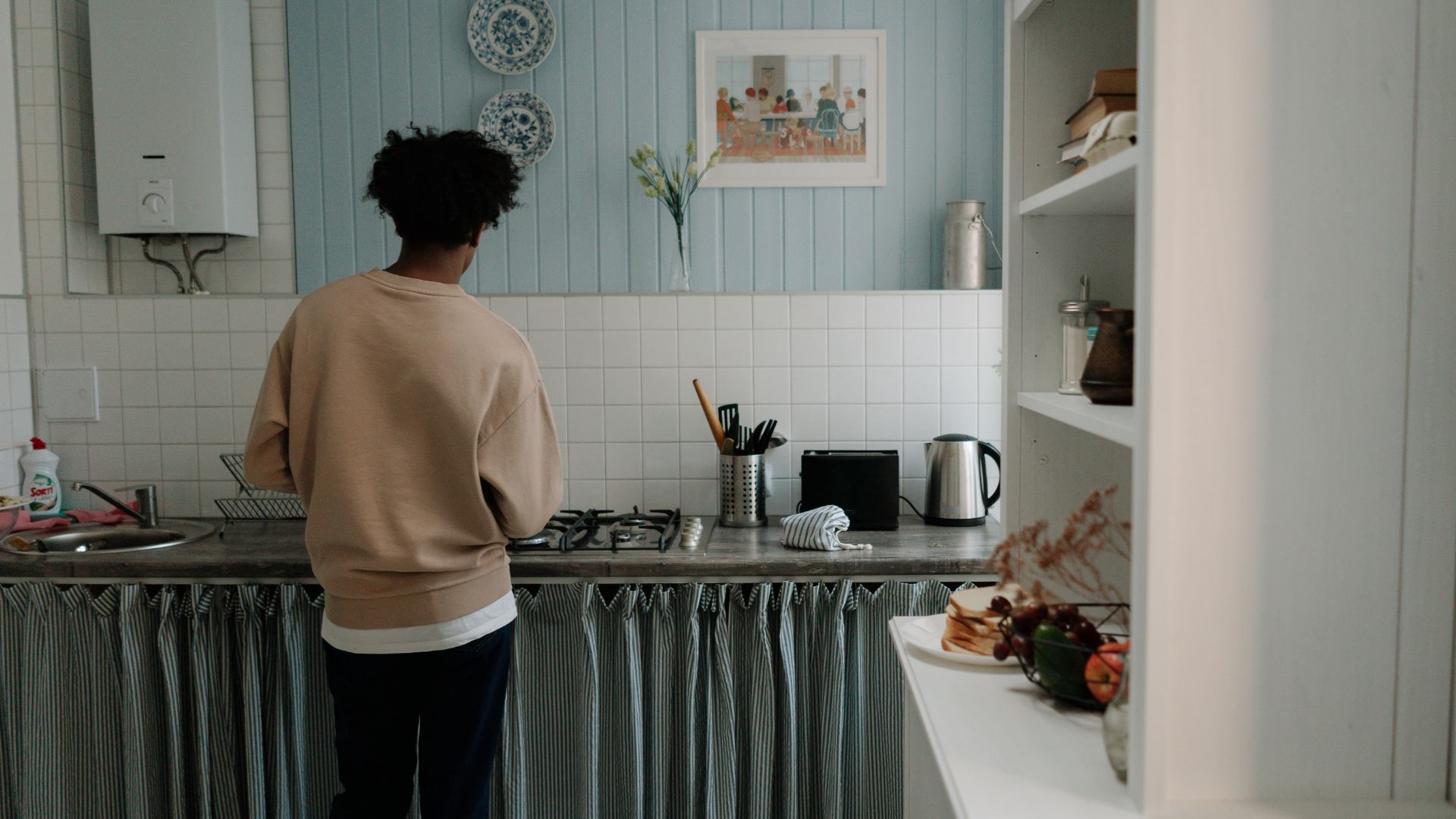Resident standing in their kitchen at home, a quiet everyday moment of settling into a new place
