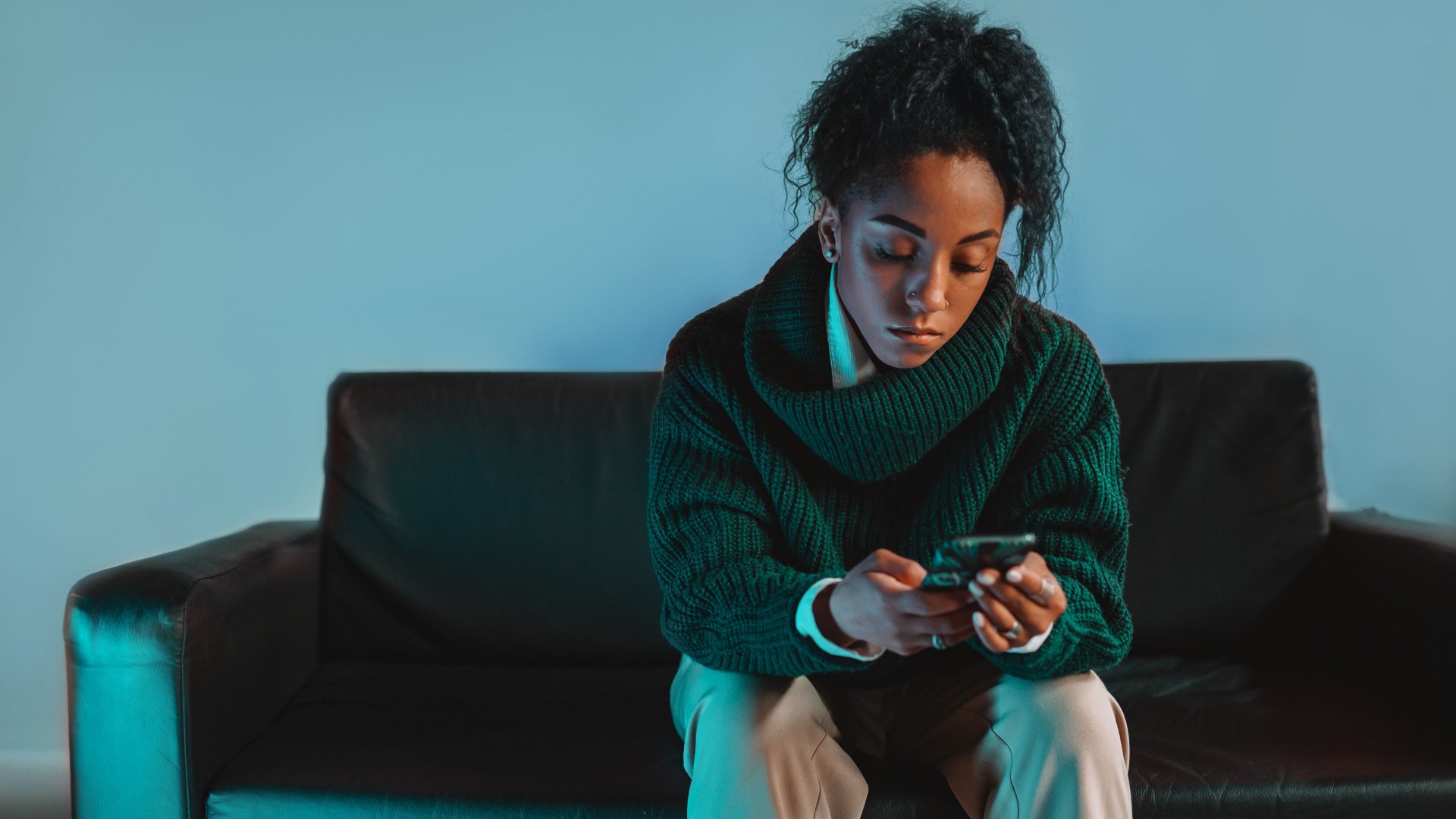 Person sitting on a couch looking at their phone