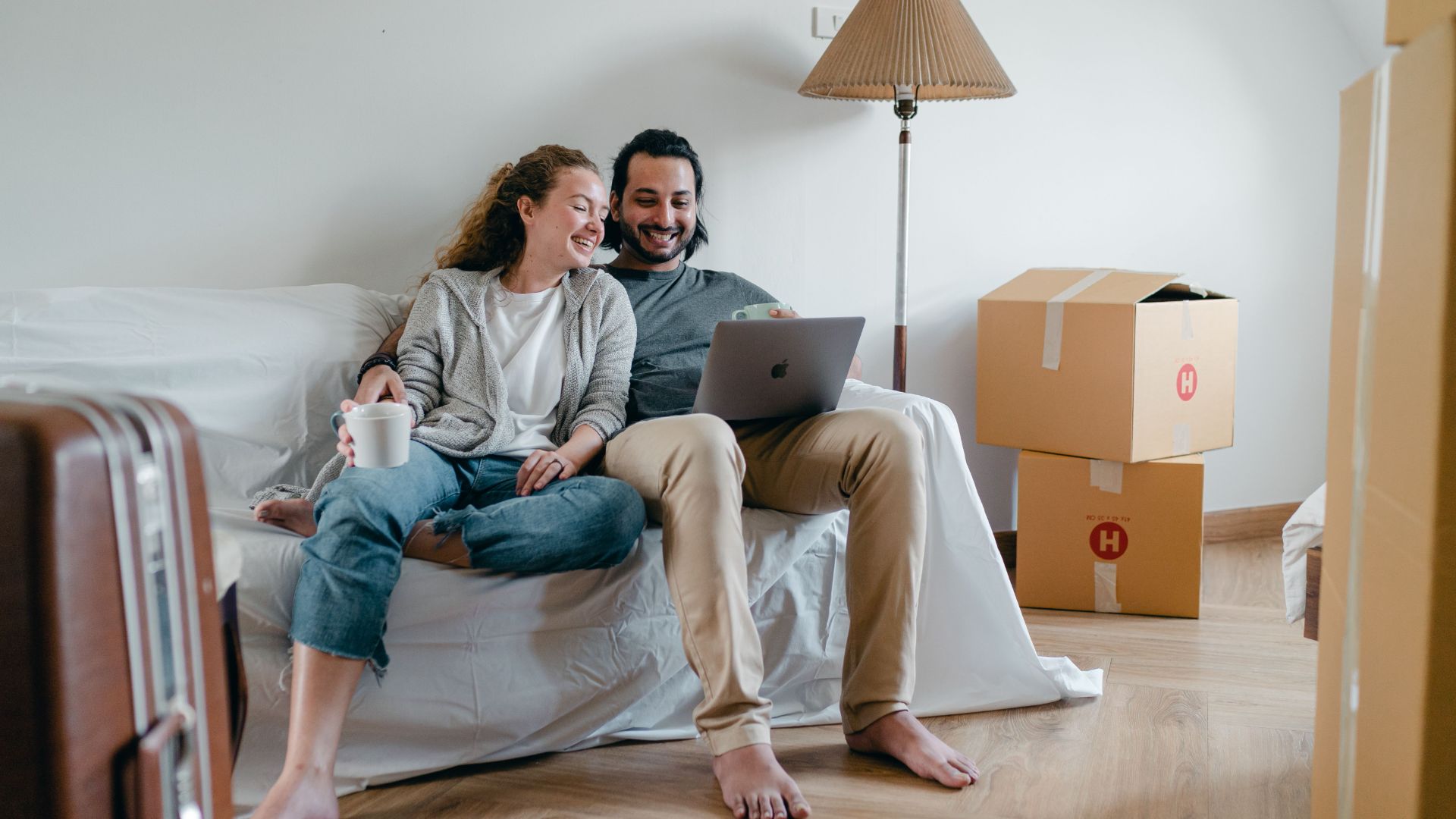a couple sitting on a couch in a newly moved in apartment