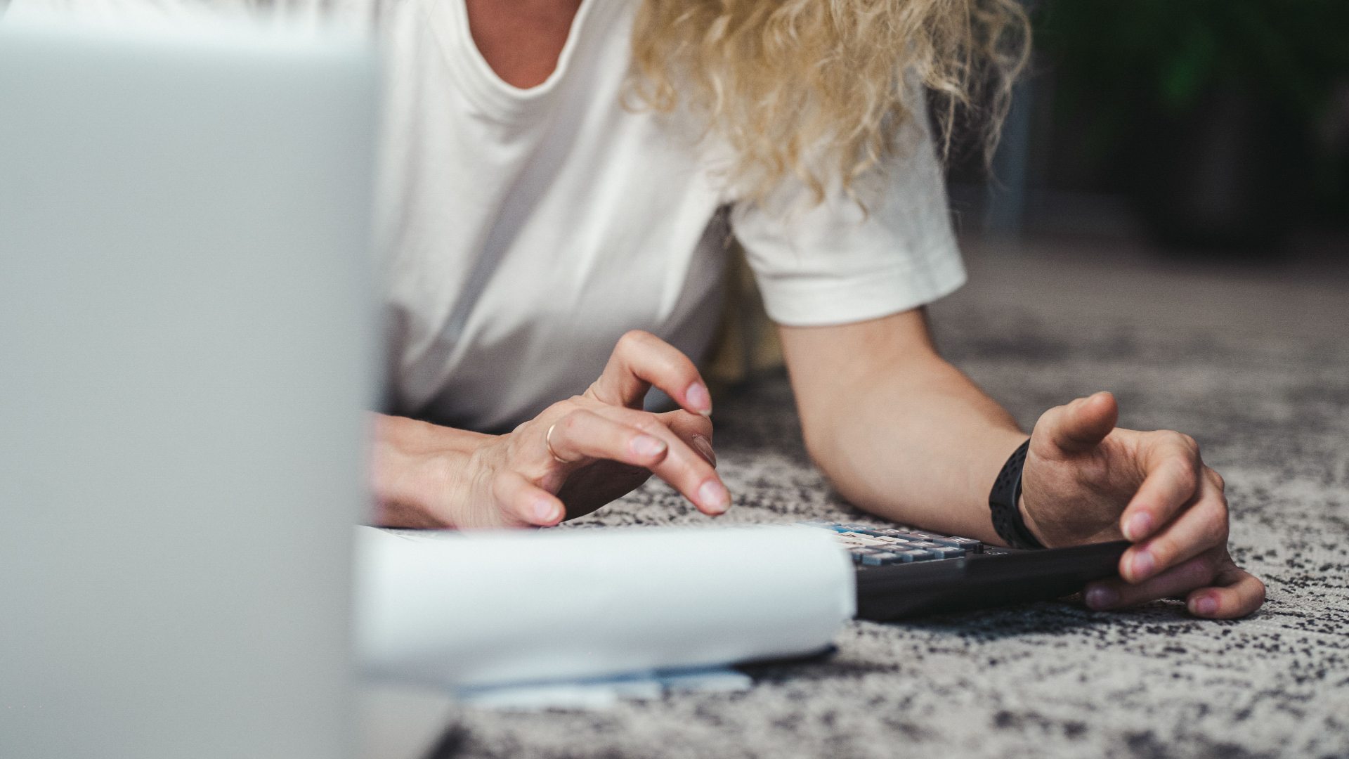 Person using a calculator beside an open laptop and financial paperwork.