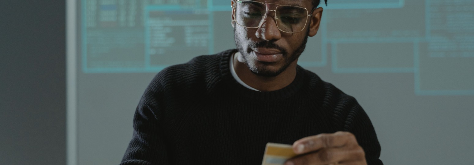 a person sitting at a computer with a credit card in his hands