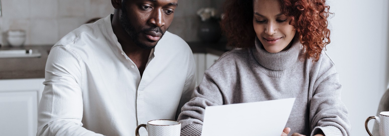 2 people sitting at d table looking at paper work