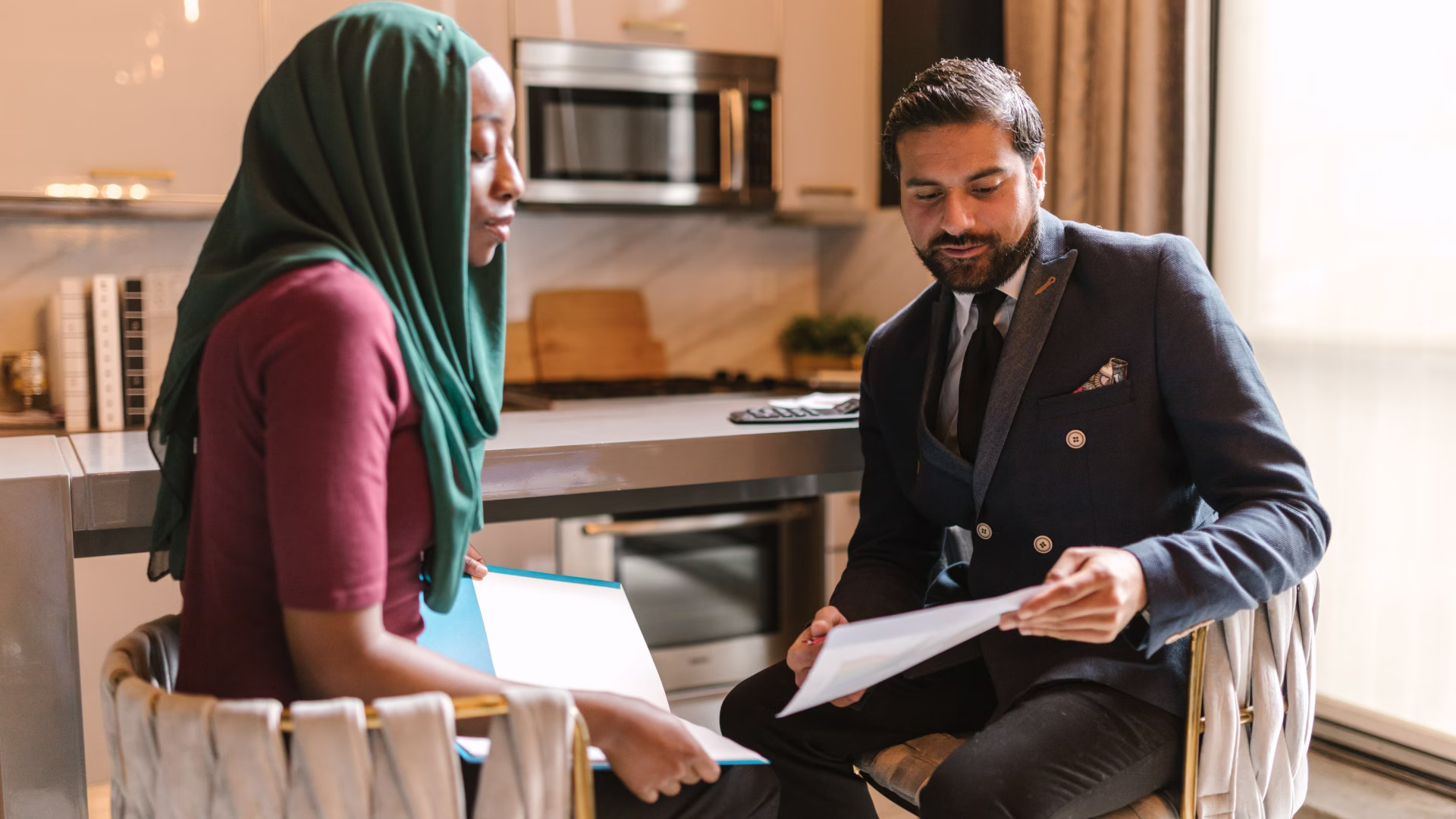 a leasing agent and a renter looking over paperwork in a kitchen