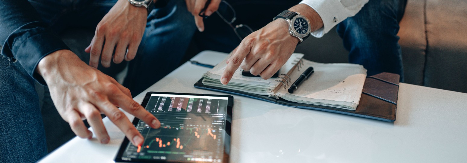 2 people sitting at a table looking over financial data
