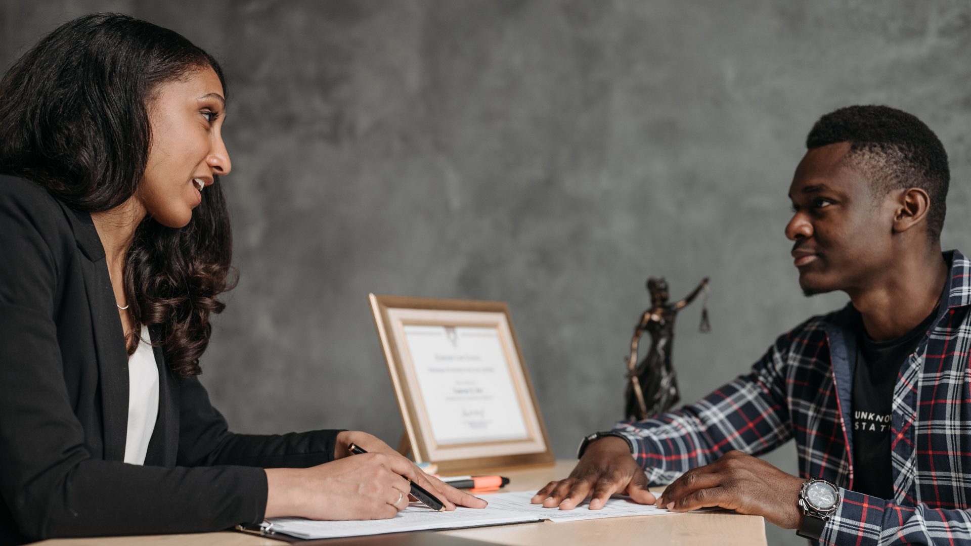 Property manager reviewing paperwork with a resident across a desk