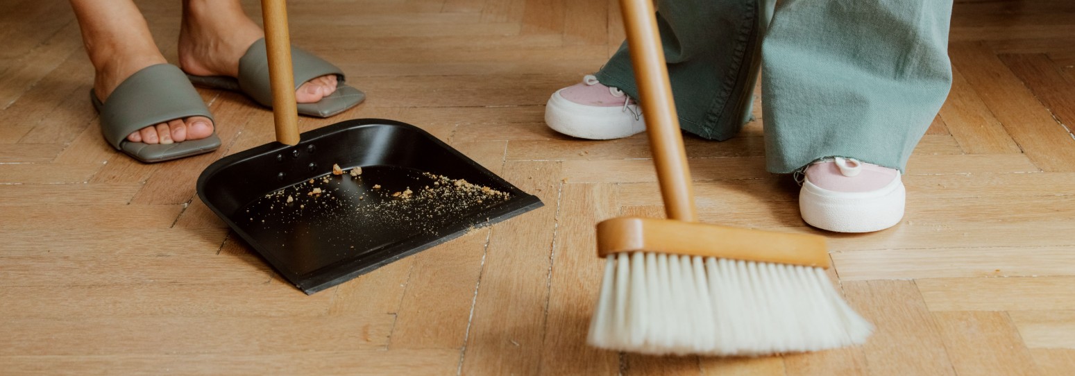 2 people sweeping a hardwood floor