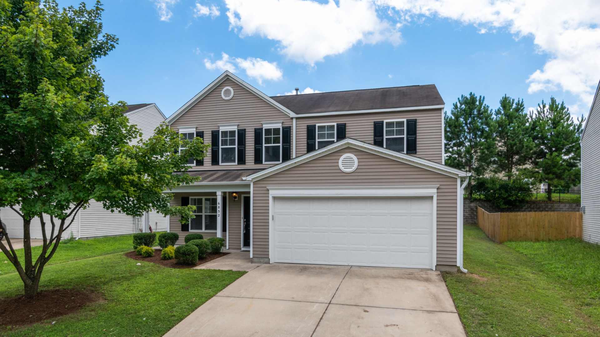 Two-story suburban home with an attached garage and front lawn.