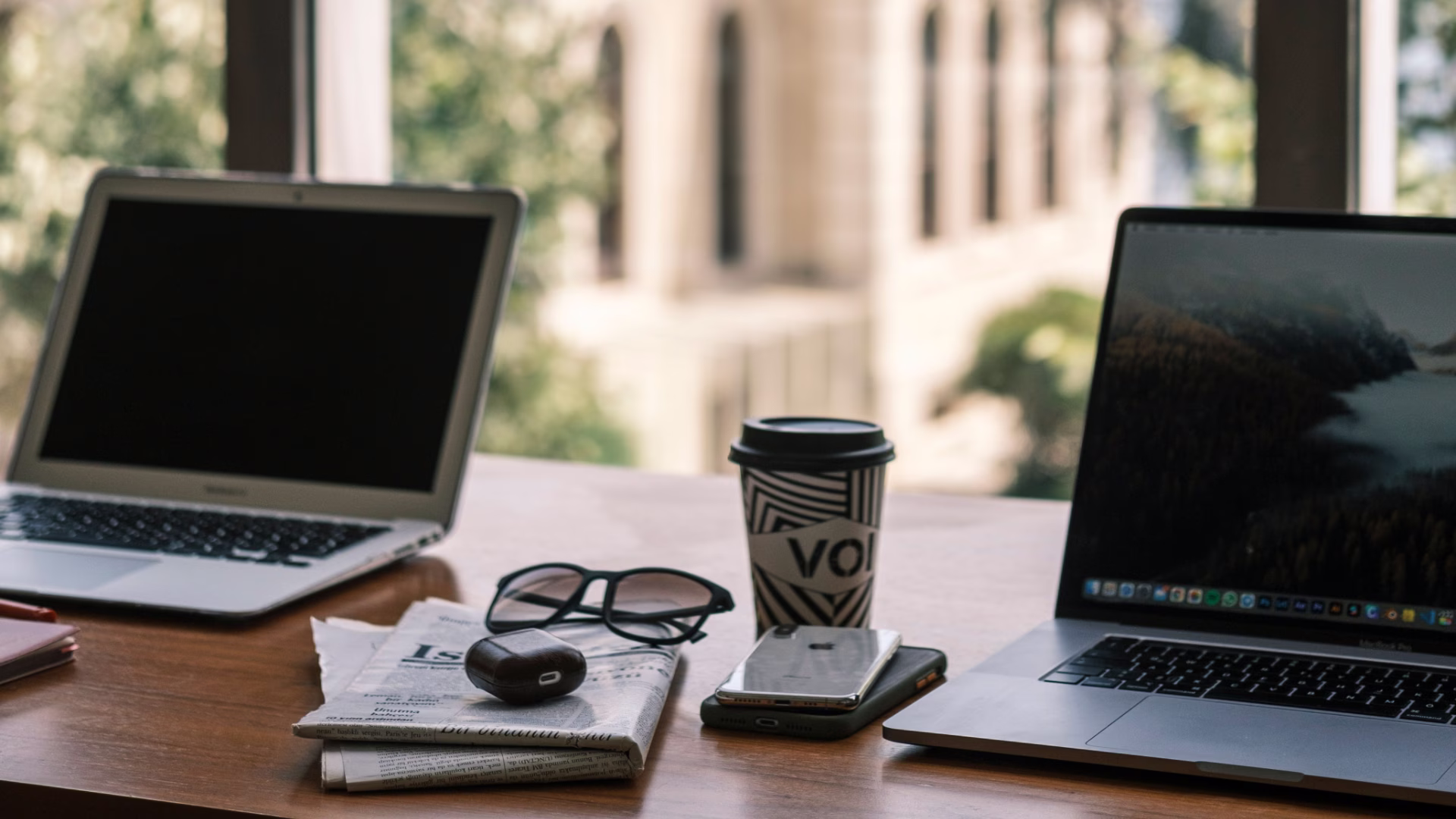 two laptops, coffee, and notebooks on a table