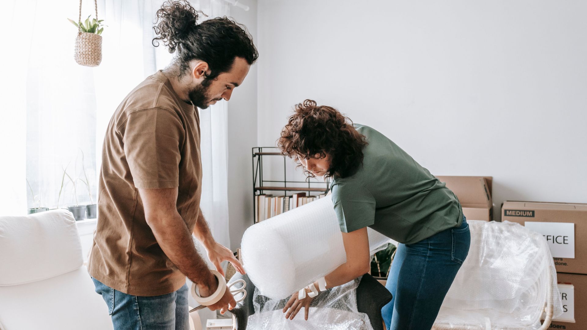 young couple unpacking moving boxes apartment