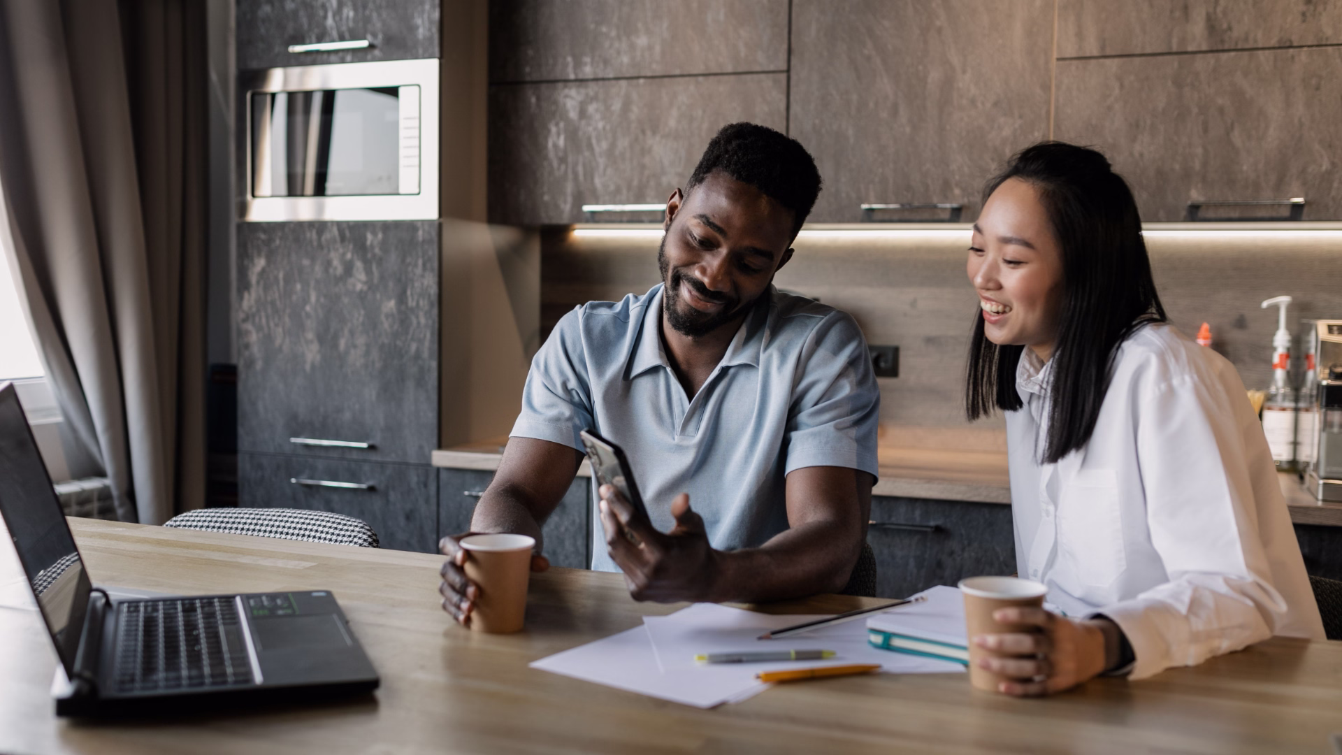 Roommates reviewing paperwork at a kitchen table 