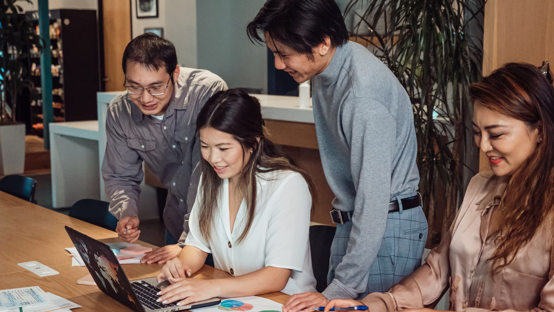 leasing office team looking at laptop together sitting at a table