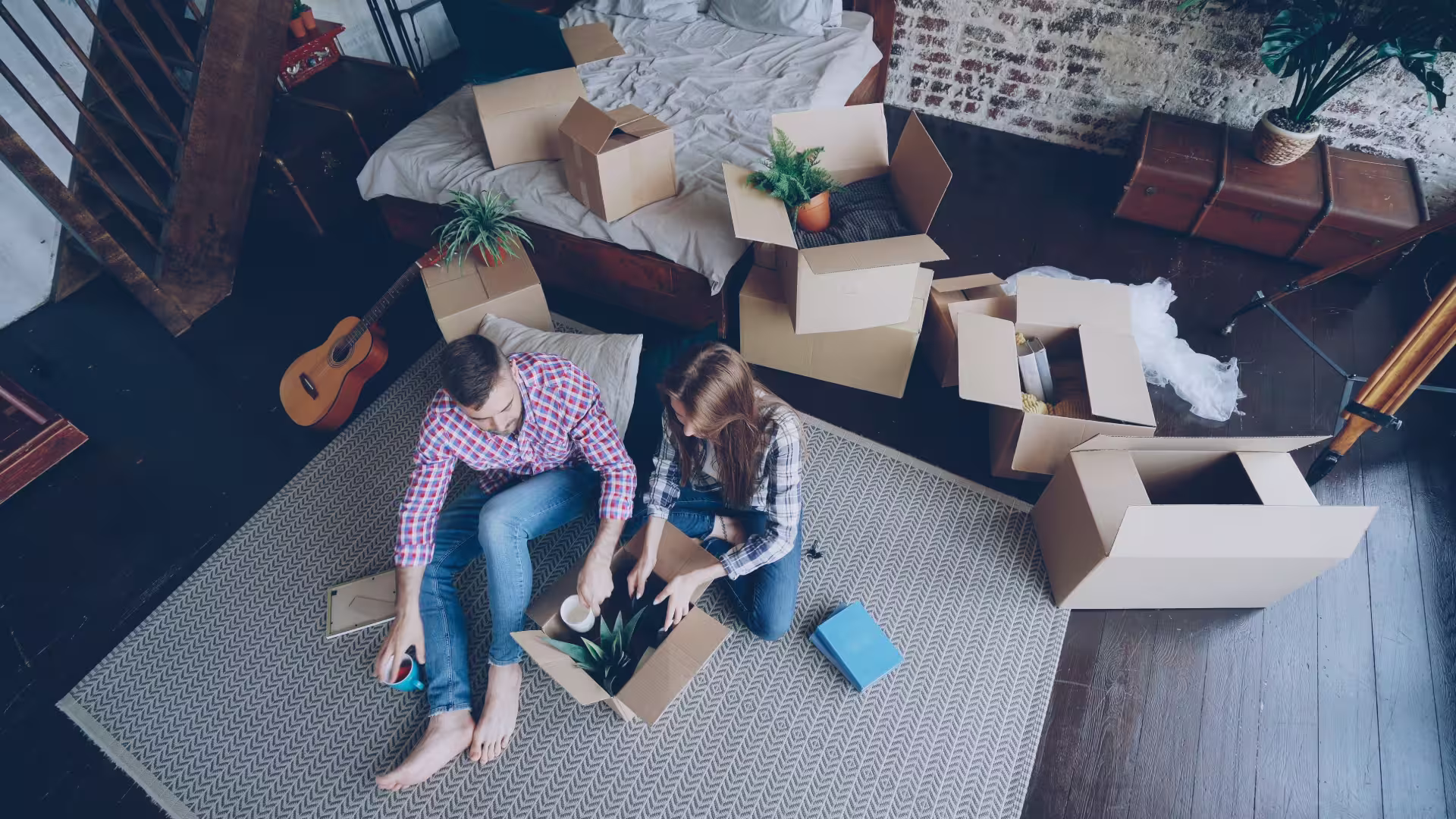 two roommates unpacking boxes in apartment living room