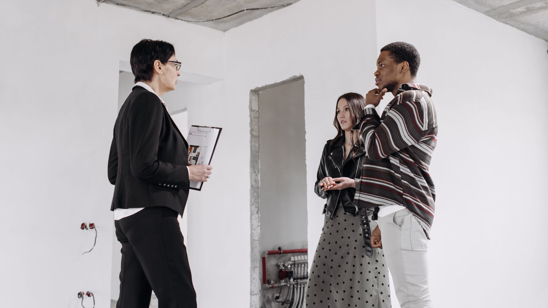 leasing office staff talking with couple touring apartment