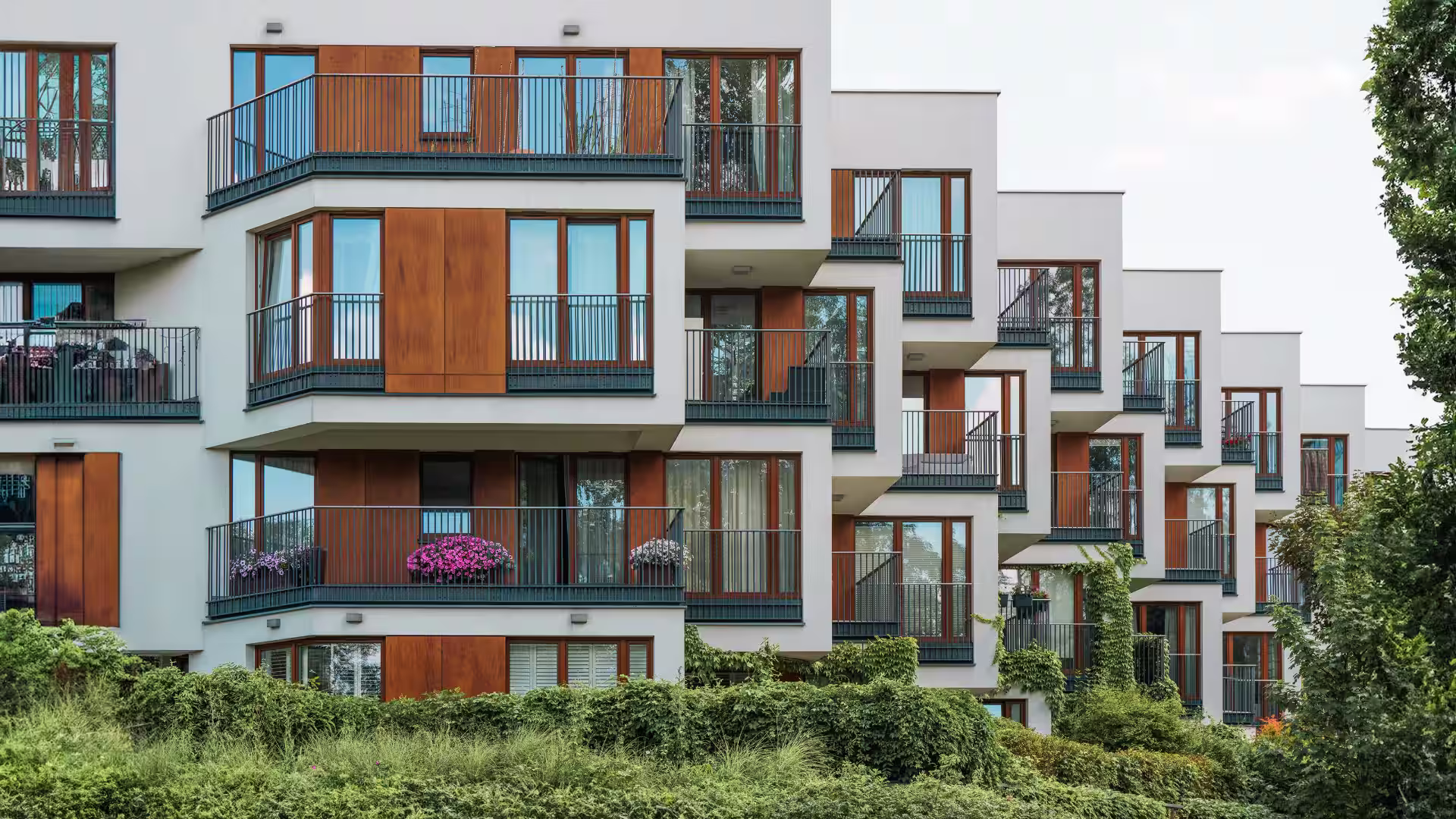 modern multifamily apartment property with plants and white exterior