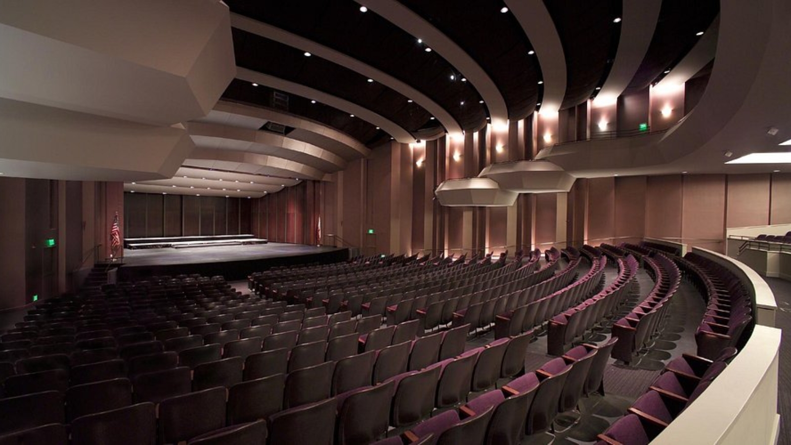 Lincoln Theater features a sophisticated auditorium with curved tiered seating, modern architectural lighting design, and a spacious stage area creating an intimate yet grand performance venue