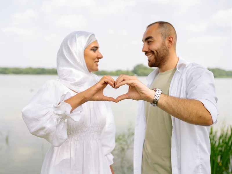 Couple forming heart shape with hands during romantic celebration