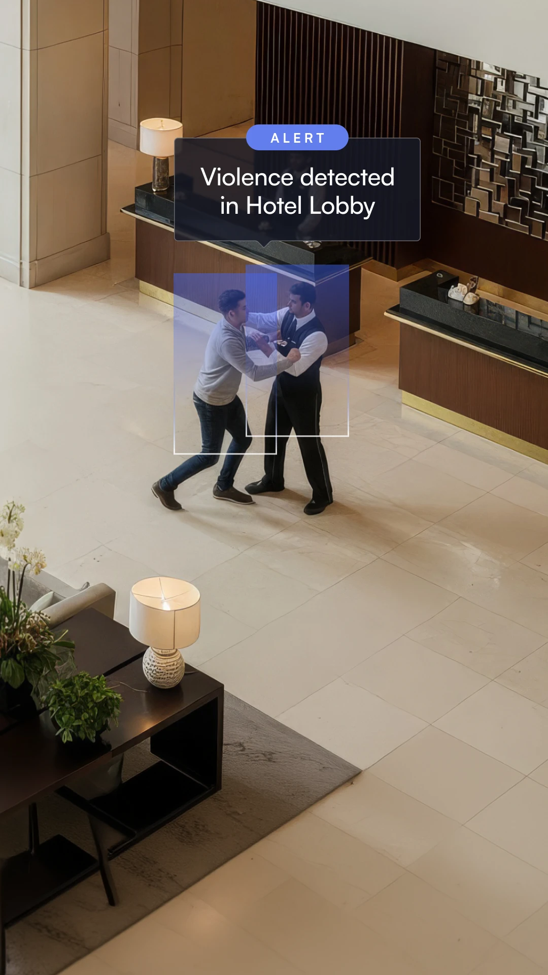 Two men engaged in a physical altercation in a hotel lobby with an alert reading 'Violence detected in Hotel Lobby'.