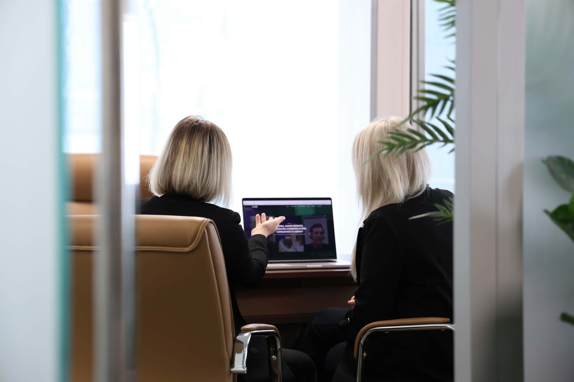Two colleagues reviewing a company website on a laptop