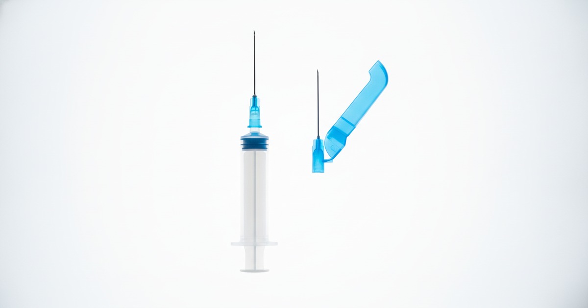 RELI WEALY retractable safety syringe and RELI safety hypodermic needle with flip shield on a backlit table