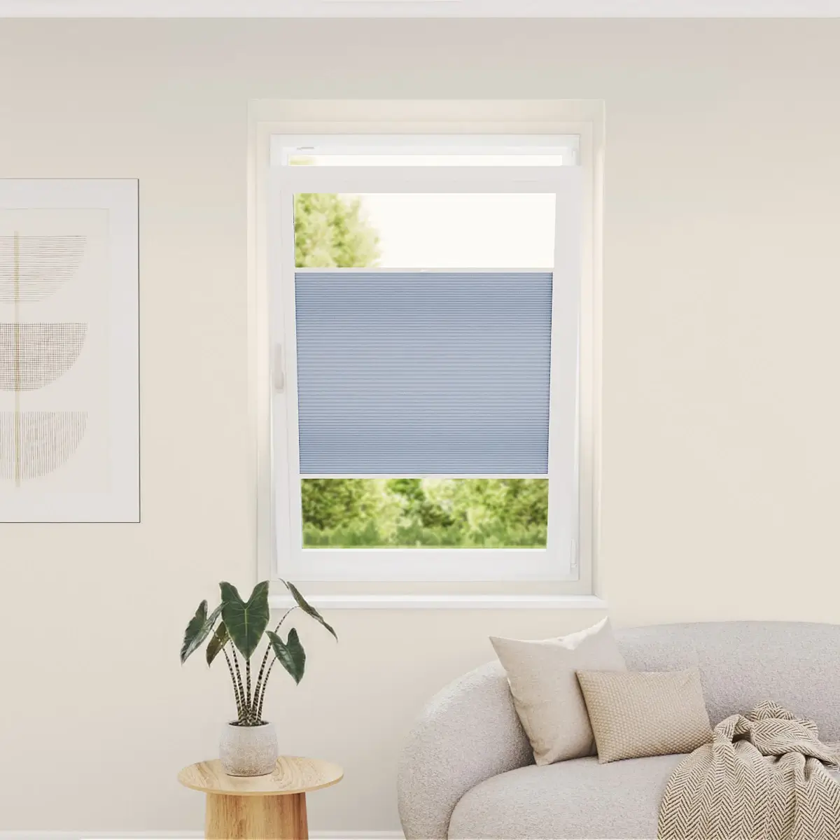 Sfeerimpressie van een plisségordijn met een wit frame en lichtblauwe stof in een modern interieur met bank.