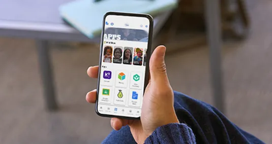 Educator using smartphone app synchronized with school website to post news and alerts instantly without double entry