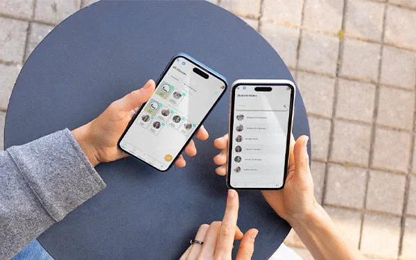 Two hands comparing K-12 school app dashboards on smartphones to track student achievements and progress
