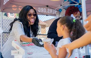 Volunteer greeting a child at a table
