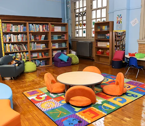 Colorful early childhood reading area in the school library with bookshelves and kid-friendly seating