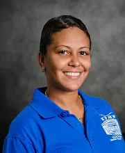 Portrait of a smiling staff member wearing a blue school polo