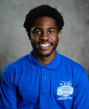 Staff portrait of a team member smiling while wearing a blue school polo shirt