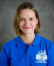 Professional staff portrait of a team member wearing a blue school polo shirt.
