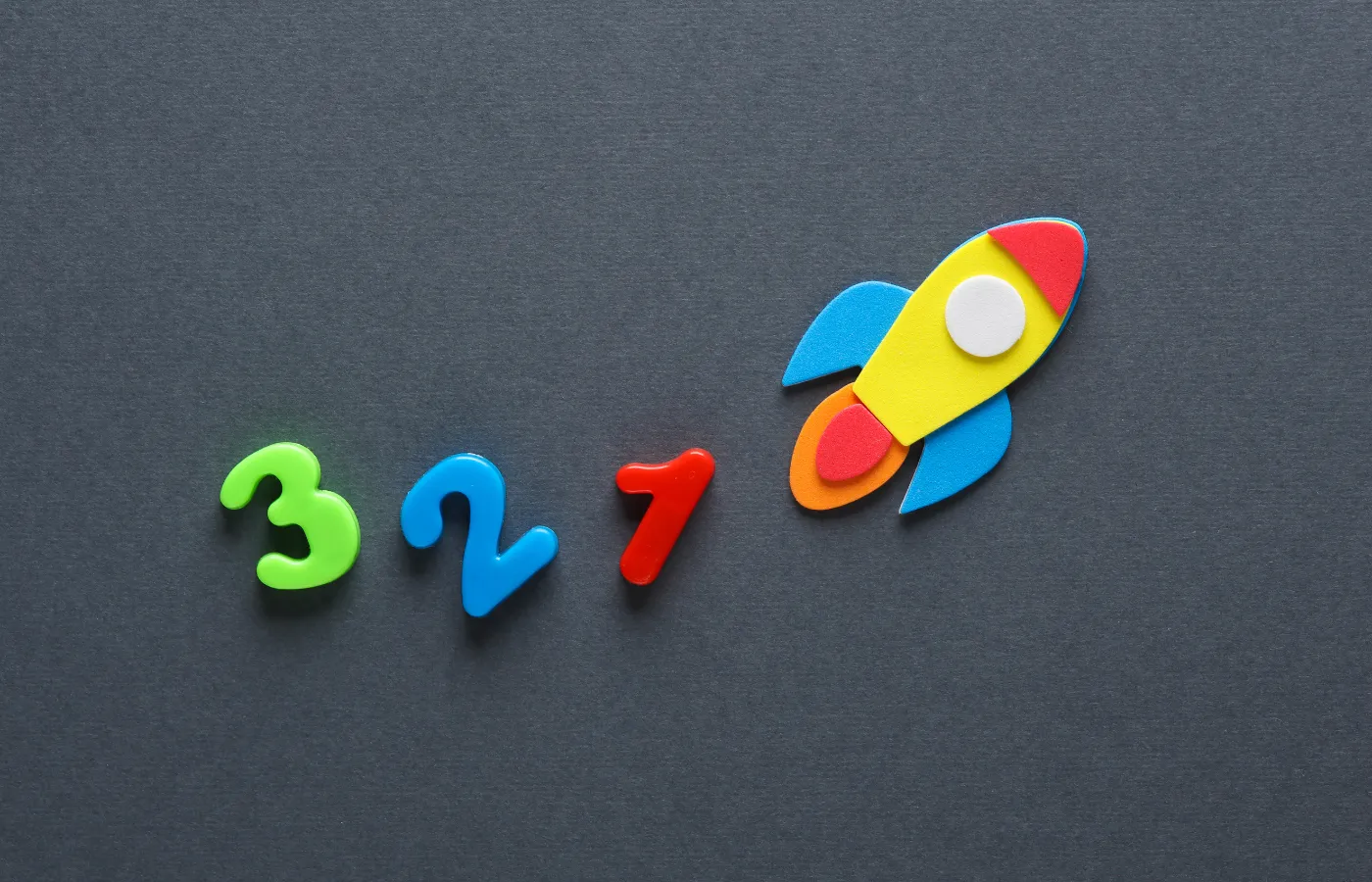 A magnet board with colorful magnets arranged as '3-2-1' and a rocket ship icon, symbolizing the simplicity and impactful nature of the 3-2-1 Exit Ticket strategy in education.