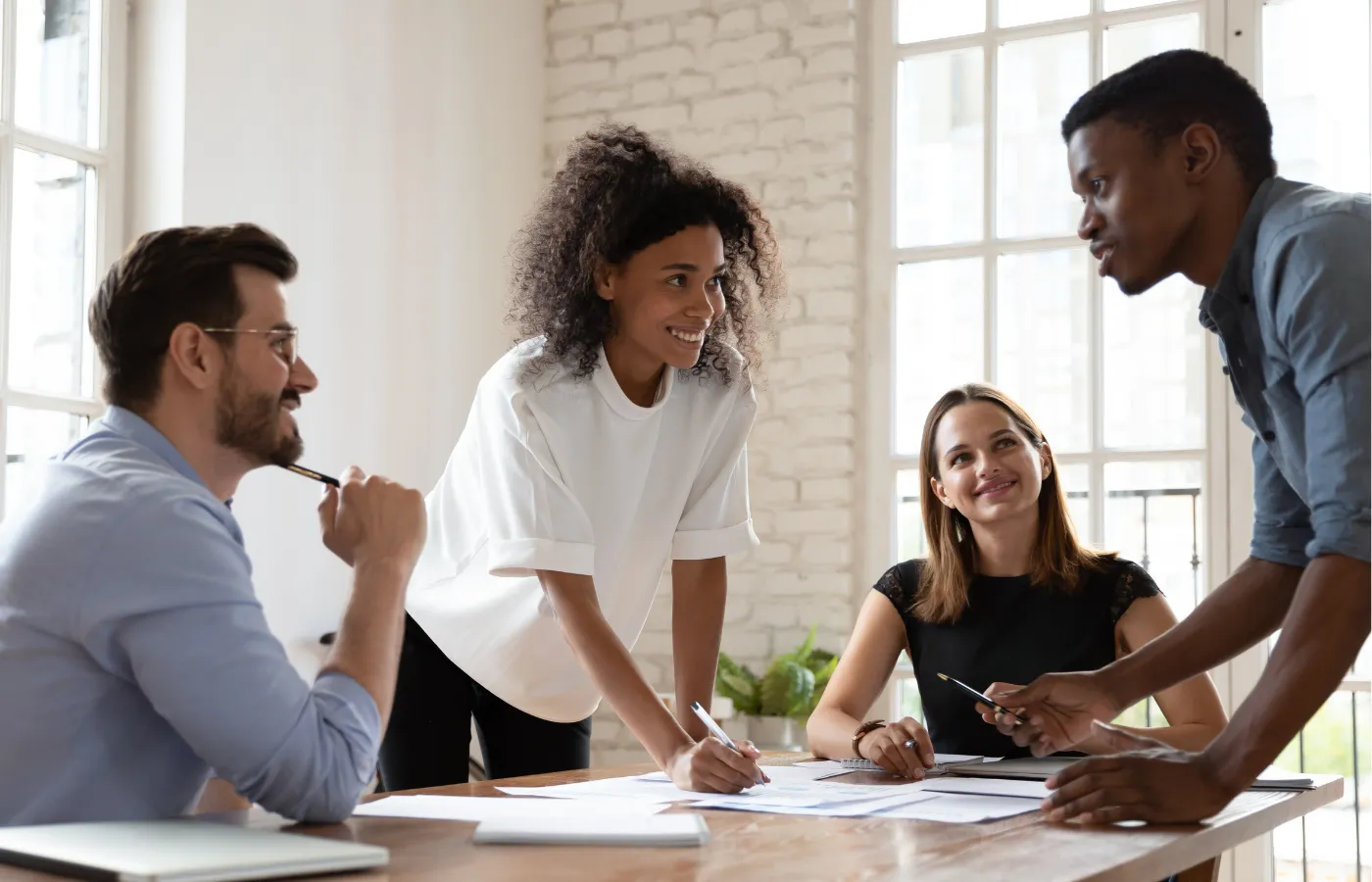 A group of teachers collaborating around a table, engaging in discussion and sharing ideas, symbolizing learning, teamwork, and professional development in an educational setting.