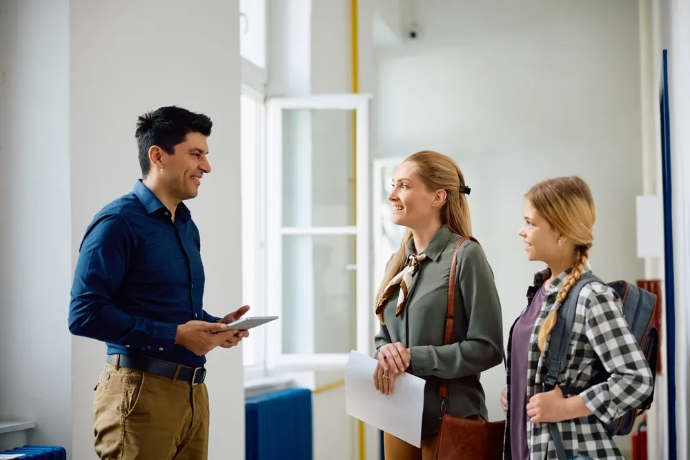 teacher with parent and student at enrollment