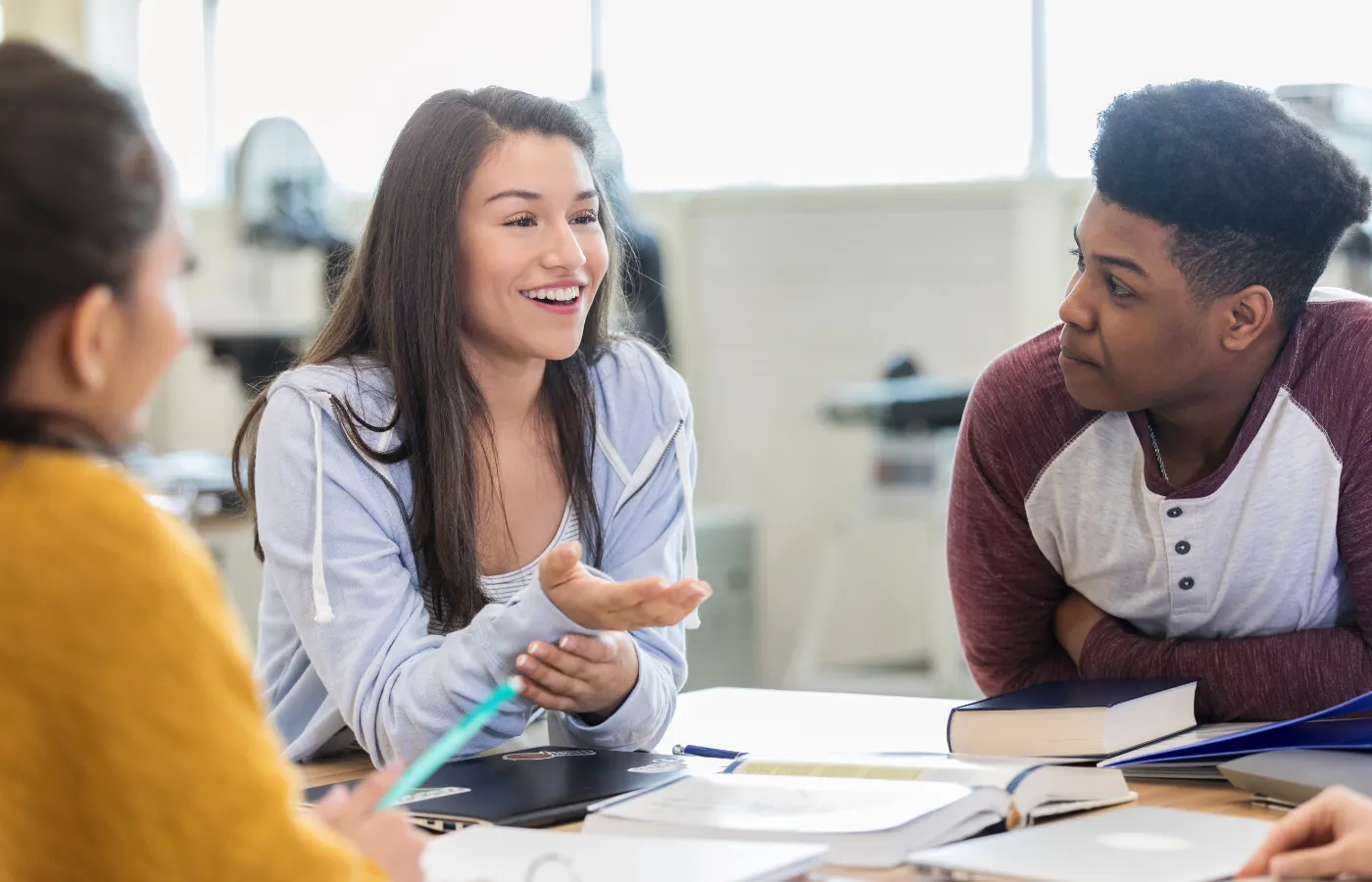 High school students in a collaborative discussion, actively problem-solving and demonstrating teamwork and critical thinking skills in a classroom setting.