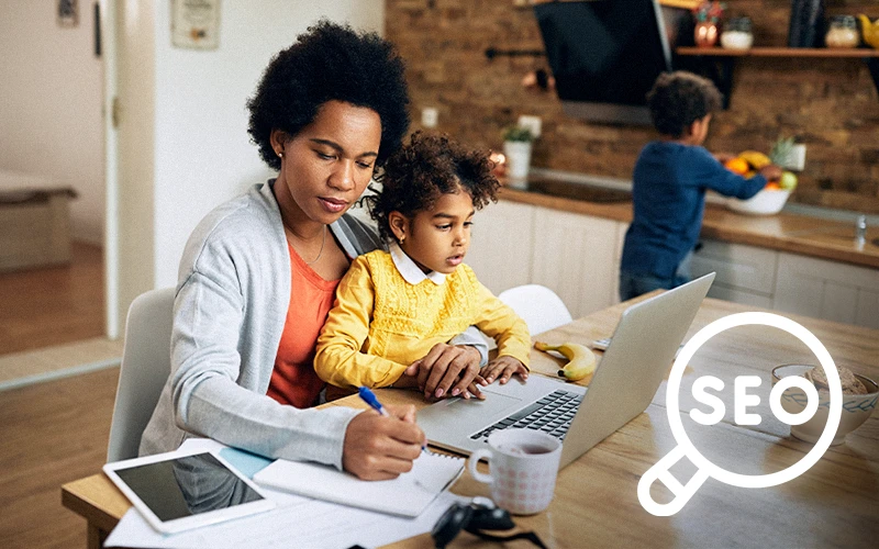 Parent researching schools online with a child at a laptop, highlighting how SEO influences family enrollment decisions.