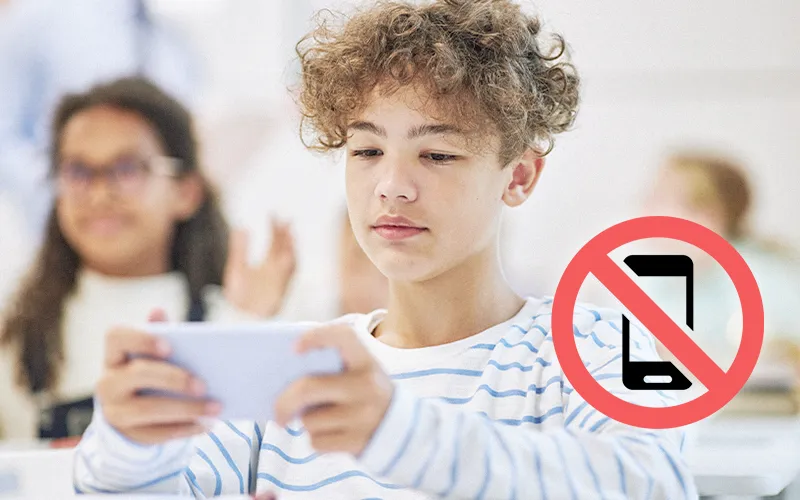 Student holding a smartphone, illustrating the need for phone-free classroom policies.