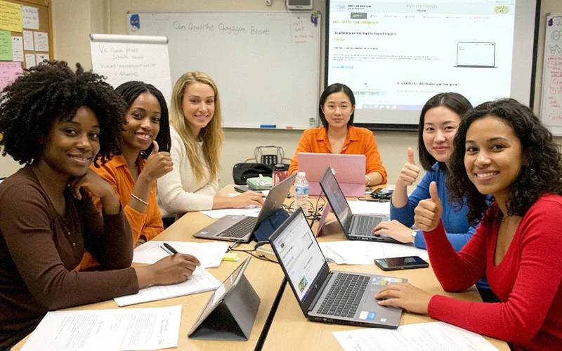 Group of educators collaborating with laptops open to SOLVED Data Dashboard during a school data team meeting