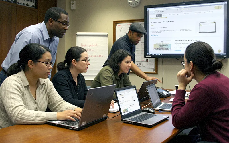 School data team collaborating in a triage meeting, combining behavior and coursework signals to prioritize interventions