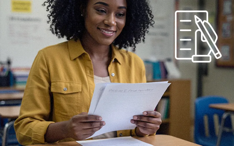 Teacher reviewing handwritten student papers in class; GRADED+ AI grading makes handwriting practical for busy educators.