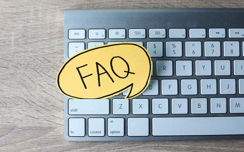 Yellow “FAQ” speech bubble on a computer keyboard, highlighting the blog’s question section