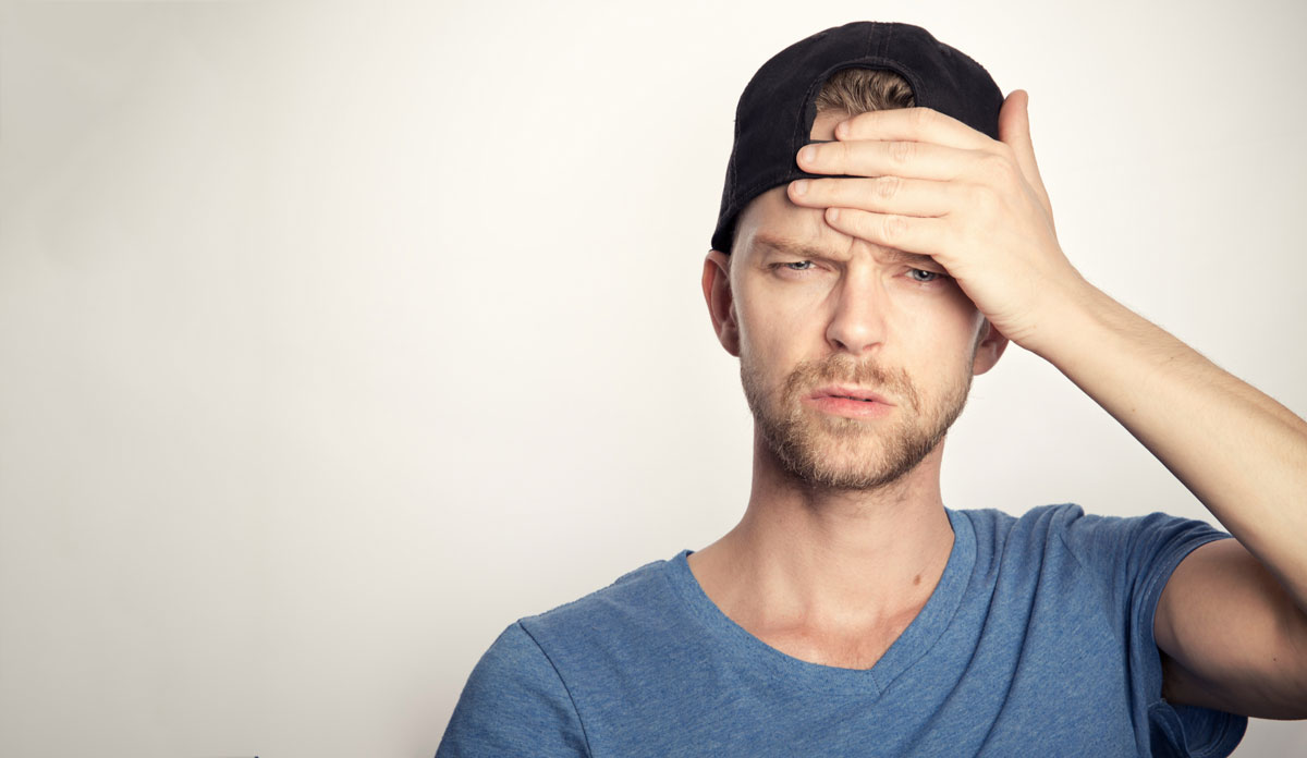 man holding hand on his forehead