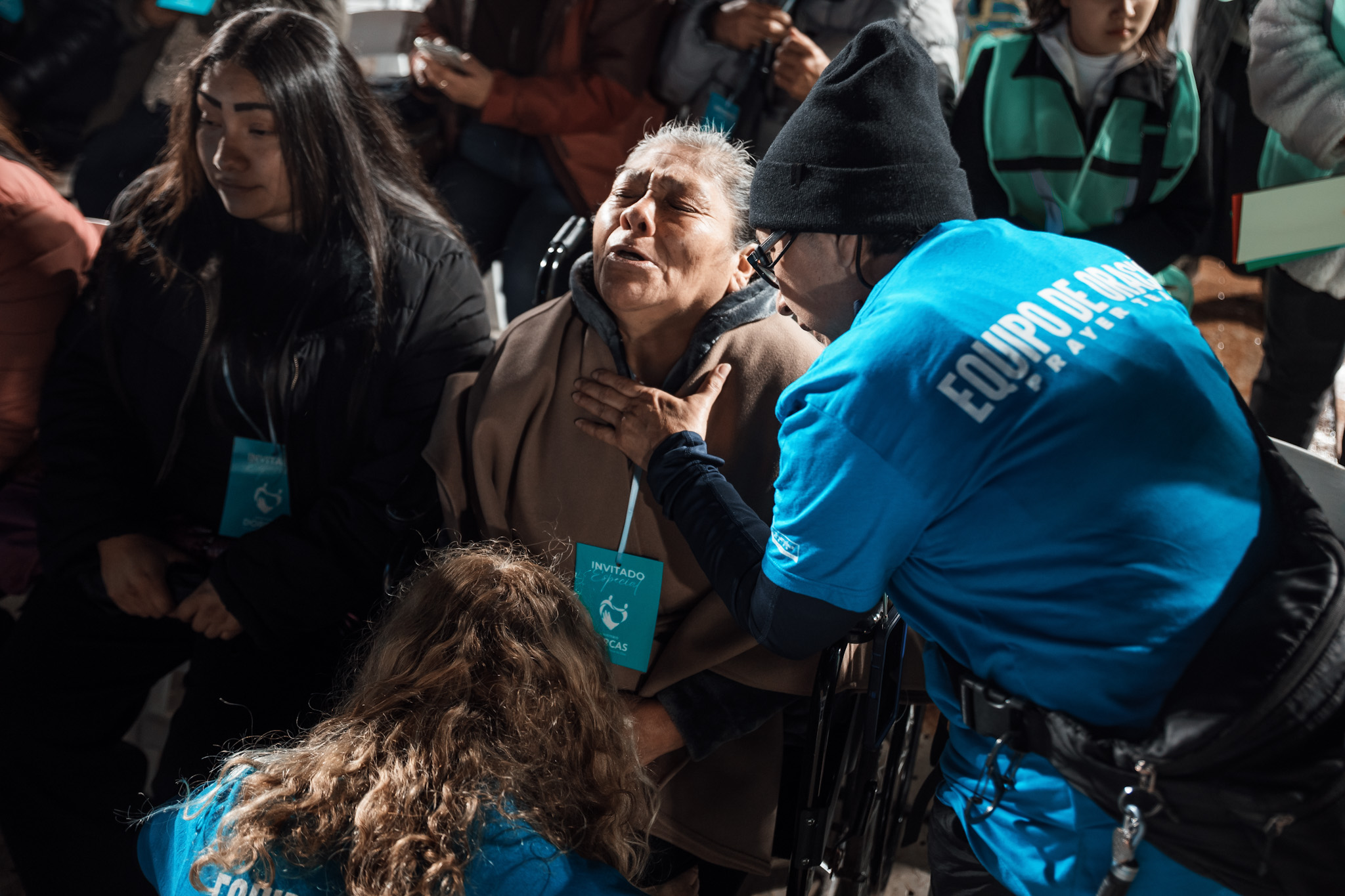 A prayer team member praying with an elderly woman during a campaign night