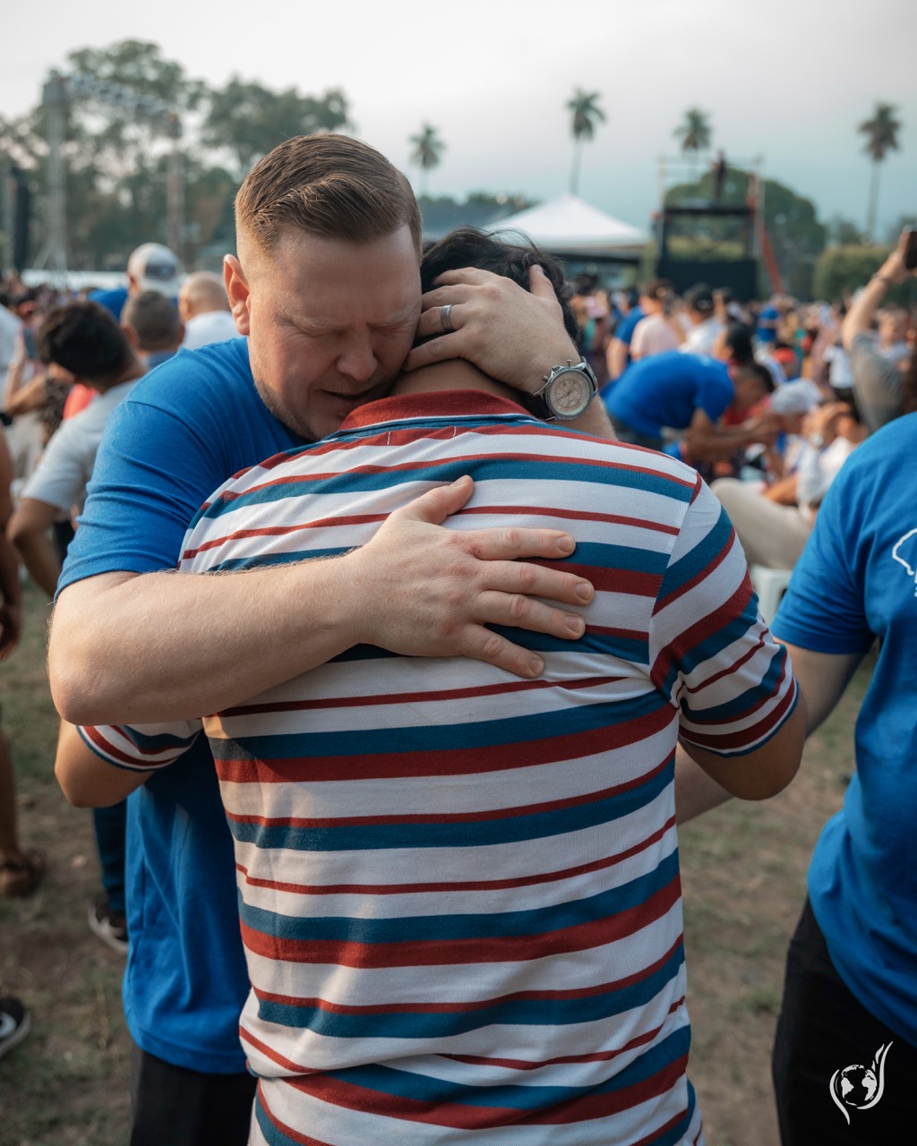 A prayer team member embracing a young man in prayer at a Gospel Campaign in San Salvador