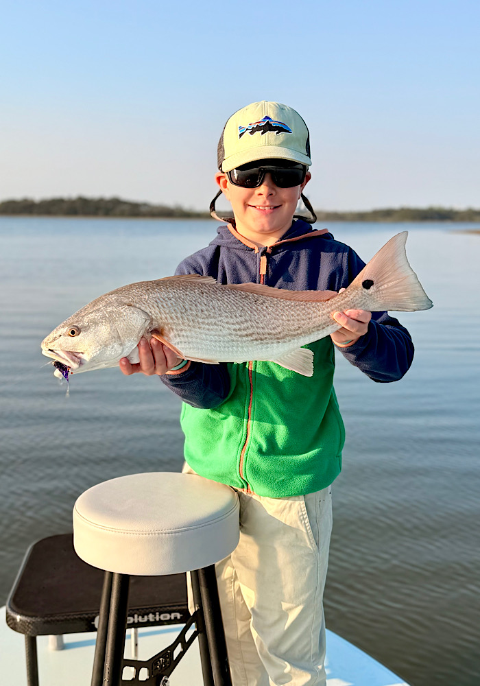 Kid with first redfish on fly