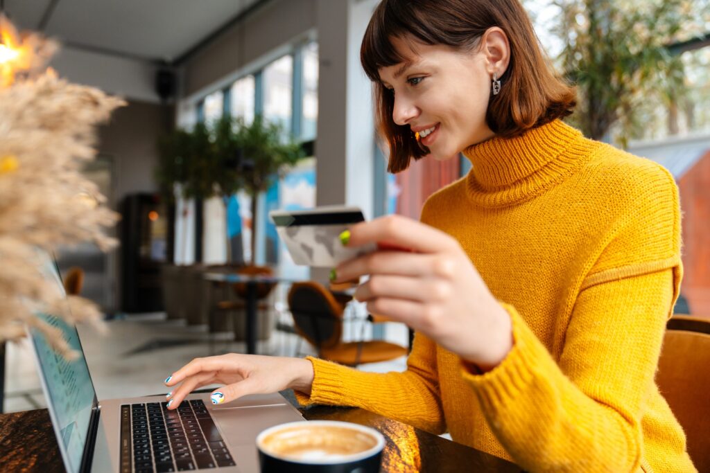 vrolijke jonge vrouw die online winkelt met haar creditcard | ELISA.io